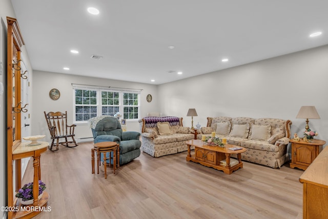 living area with visible vents, light wood-style flooring, and recessed lighting