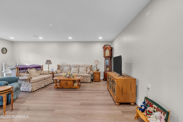 living area with light wood-type flooring, baseboards, and recessed lighting