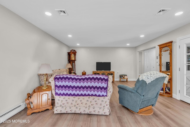 living area featuring a baseboard heating unit, light wood-style flooring, visible vents, and recessed lighting