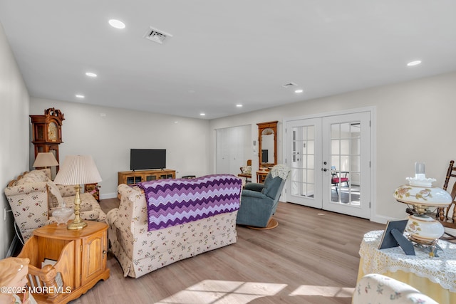 living room with recessed lighting, french doors, visible vents, and light wood finished floors