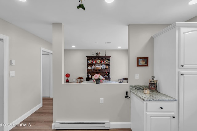 kitchen with recessed lighting, light countertops, a baseboard heating unit, white cabinetry, and wood finished floors