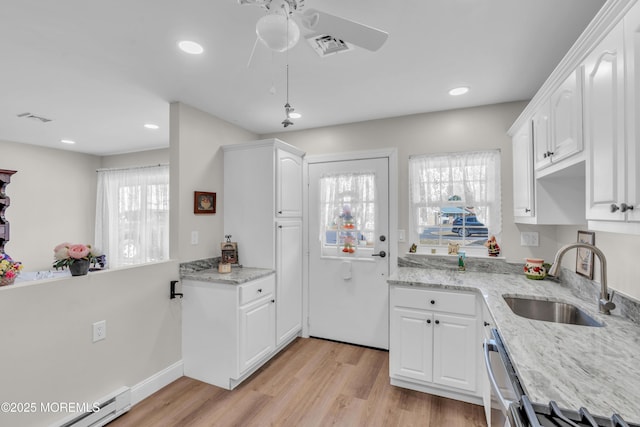 kitchen featuring a baseboard radiator, white cabinets, and a sink