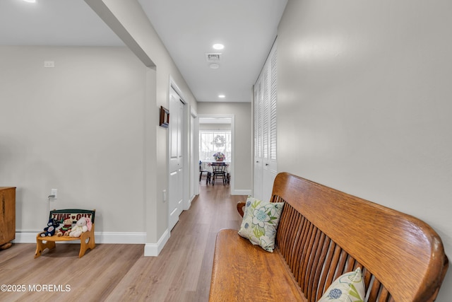 hallway with light wood-type flooring, visible vents, baseboards, and recessed lighting