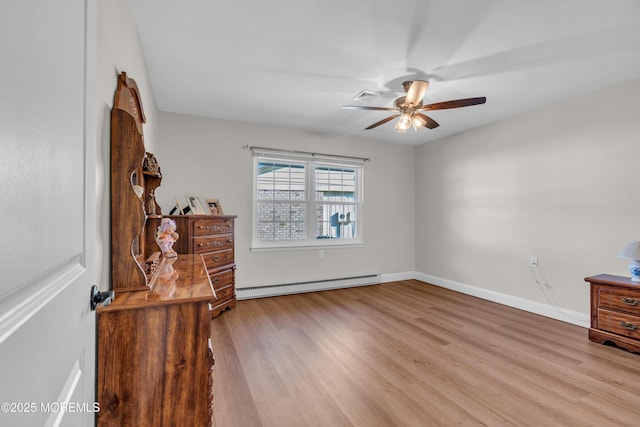 unfurnished room featuring visible vents, baseboards, ceiling fan, wood finished floors, and baseboard heating