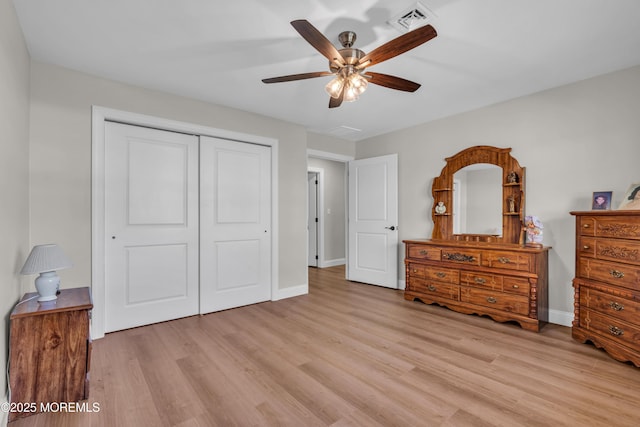 bedroom with light wood-type flooring, a closet, visible vents, and baseboards