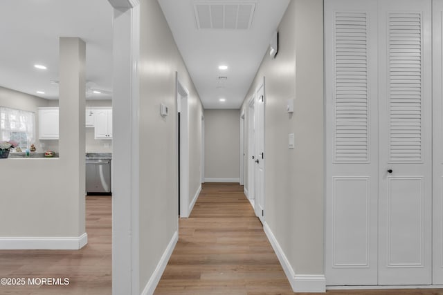 hallway featuring recessed lighting, light wood-type flooring, visible vents, and baseboards