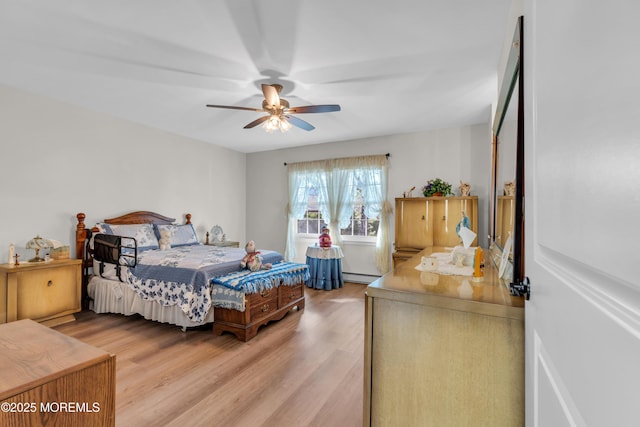 bedroom featuring ceiling fan, baseboard heating, and light wood-style flooring