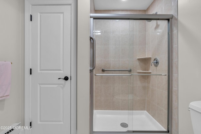 full bath with a stall shower and toilet