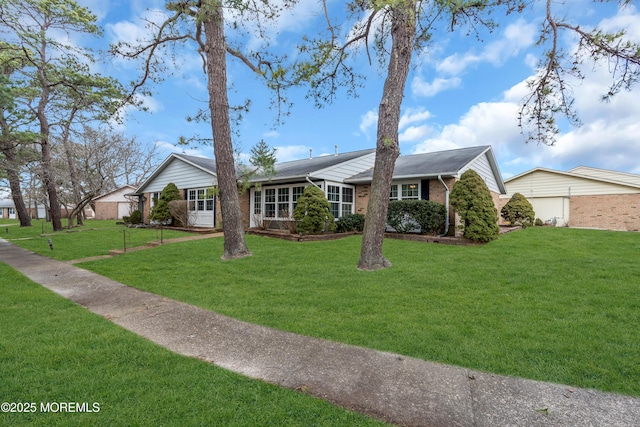 ranch-style home featuring brick siding and a front lawn