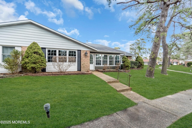 ranch-style house with a front lawn and brick siding