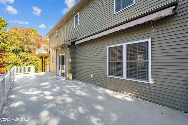 view of property exterior featuring a patio area and a balcony