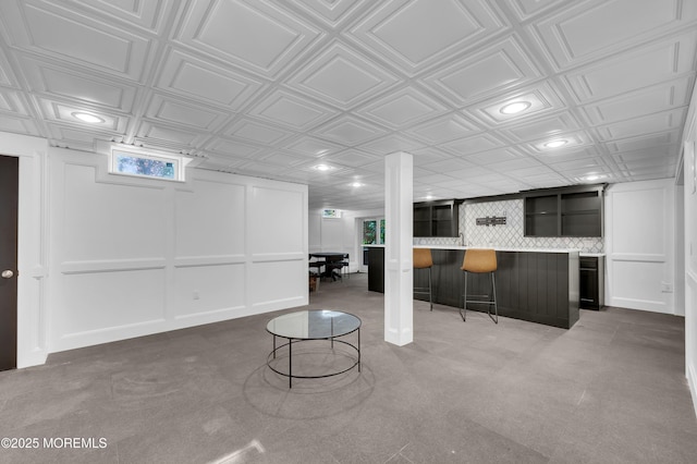 below grade area featuring a community bar, an ornate ceiling, and recessed lighting