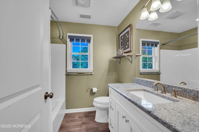 full bath with visible vents, toilet, vanity, wood finished floors, and baseboards