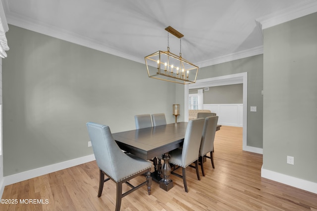 dining space with a chandelier, baseboards, light wood-style flooring, and crown molding