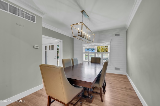 dining area featuring ornamental molding, baseboards, and wood finished floors