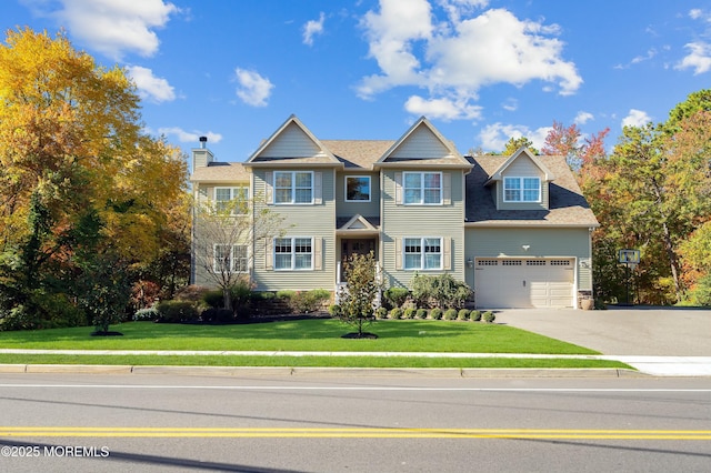 view of front of property with driveway, an attached garage, and a front lawn