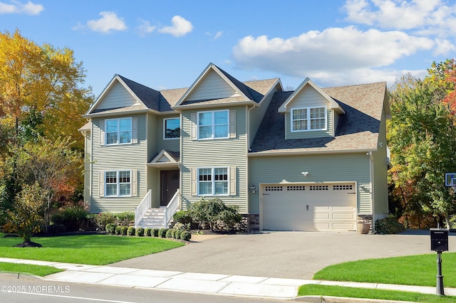 view of front of house with aphalt driveway, a front yard, and an attached garage