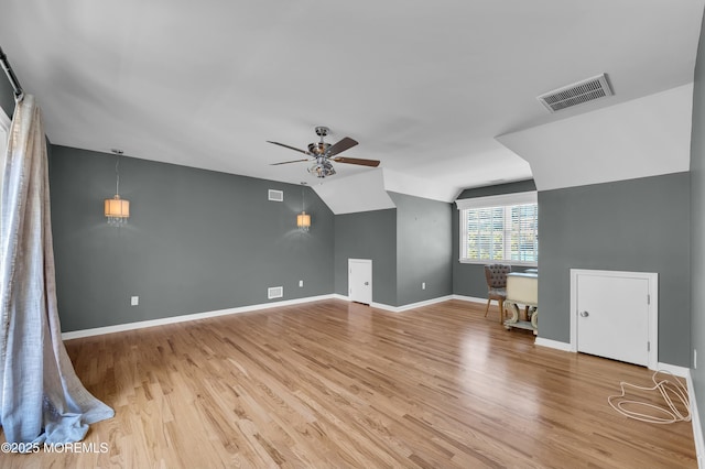 bonus room with lofted ceiling, light wood finished floors, baseboards, and visible vents