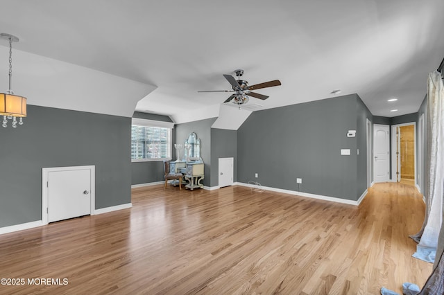 additional living space featuring lofted ceiling, light wood finished floors, baseboards, and a ceiling fan