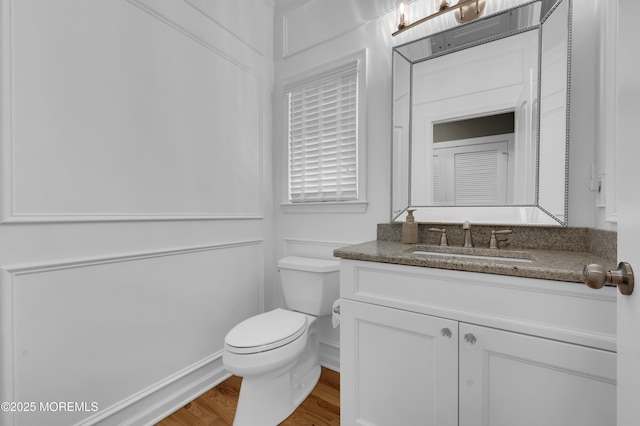 bathroom with vanity, wood finished floors, and toilet