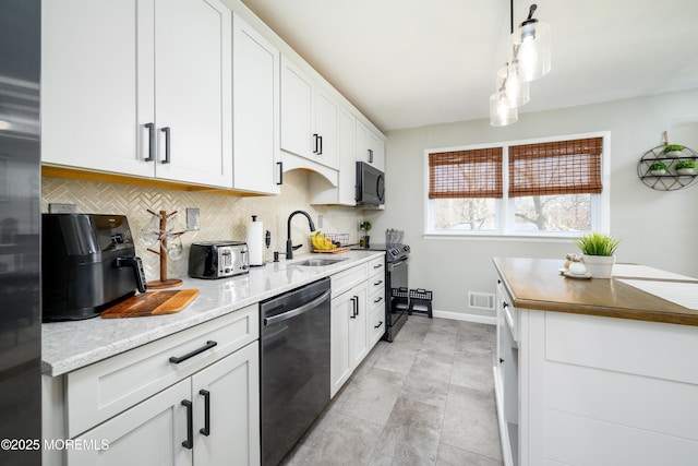 kitchen with visible vents, a sink, decorative backsplash, stainless steel appliances, and white cabinetry