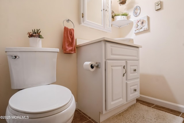 bathroom featuring baseboards, toilet, and tile patterned flooring