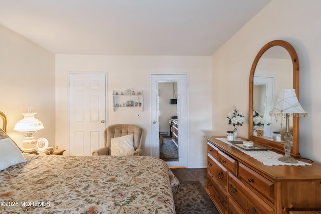 bedroom featuring dark colored carpet and arched walkways