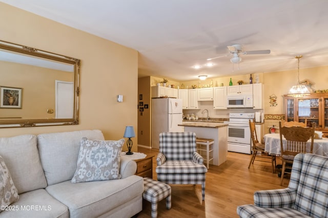 living room featuring light wood-type flooring and ceiling fan