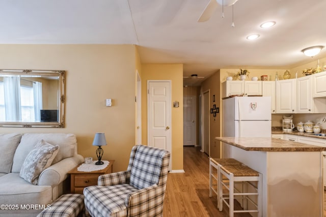 living area featuring recessed lighting, light wood finished floors, and ceiling fan