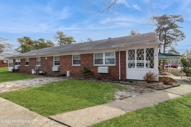 single story home featuring a front lawn, a carport, and brick siding