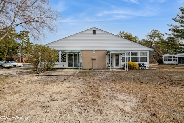 rear view of house featuring a sunroom