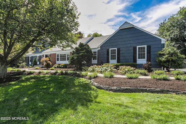 view of front of house featuring a chimney and a front lawn