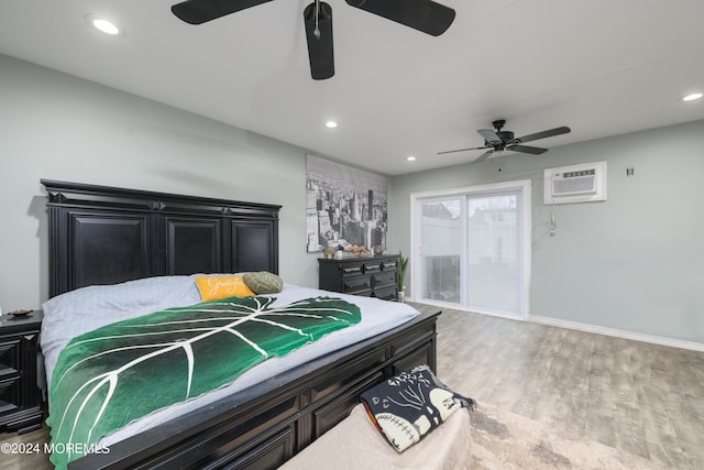 bedroom with recessed lighting, an AC wall unit, access to outside, and wood finished floors