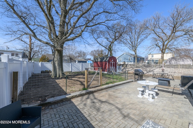 view of patio with an outbuilding, a barn, a fenced backyard, and a residential view