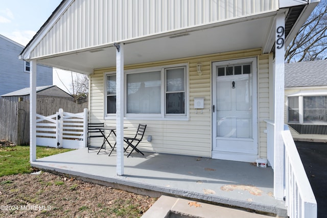 view of exterior entry featuring a patio area and fence