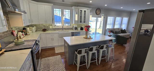 kitchen featuring a sink, open floor plan, wall chimney range hood, dishwasher, and plenty of natural light