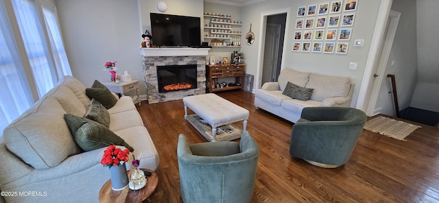 living room with a fireplace, wood finished floors, and crown molding