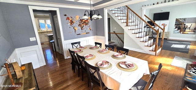 dining room with stairs, a chandelier, wood finished floors, and wainscoting