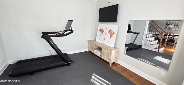 exercise area with dark wood finished floors and baseboards