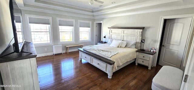 bedroom with dark wood-style flooring, baseboards, ornamental molding, radiator heating unit, and a raised ceiling