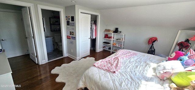 bedroom with lofted ceiling, connected bathroom, baseboards, and wood finished floors