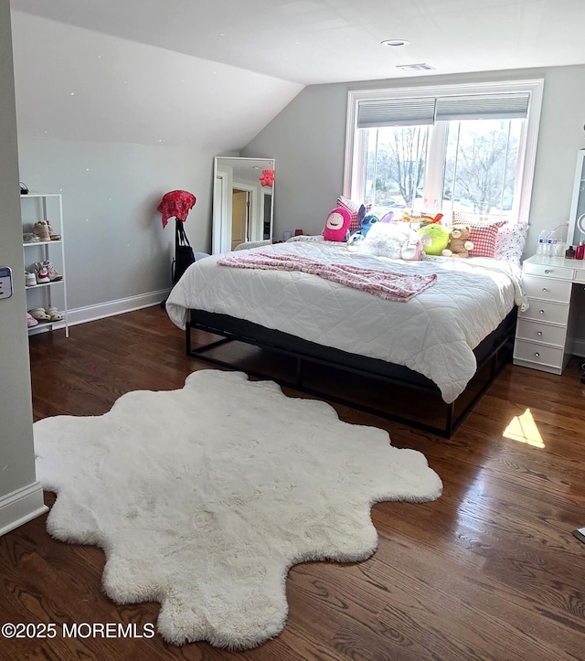 bedroom with lofted ceiling, baseboards, and wood finished floors