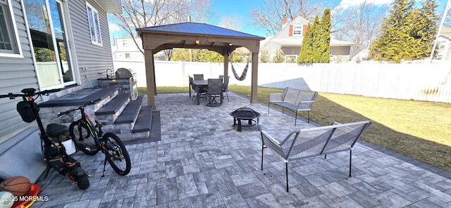 view of patio featuring fence, a fire pit, and a gazebo