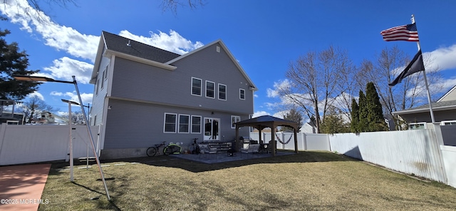 back of property with entry steps, a fenced backyard, a gazebo, a yard, and a patio area