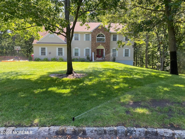 colonial-style house with a front lawn and brick siding