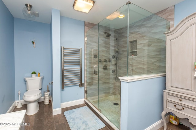 bathroom featuring a shower stall, radiator heating unit, baseboards, and wood tiled floor