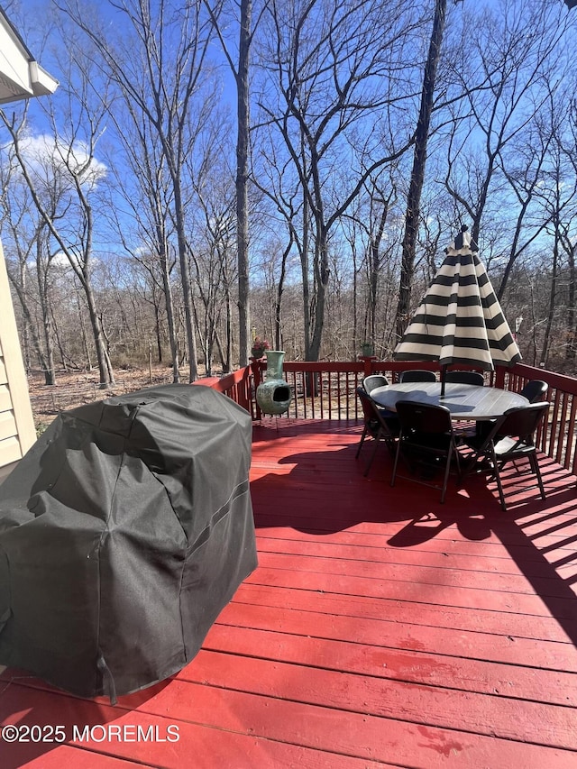 wooden deck with area for grilling and outdoor dining space