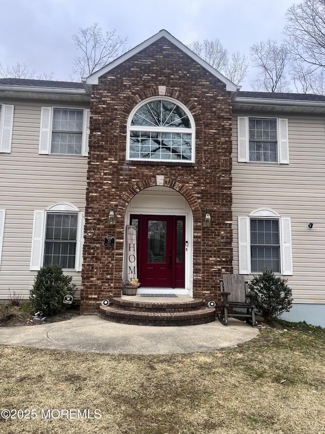 entrance to property featuring brick siding