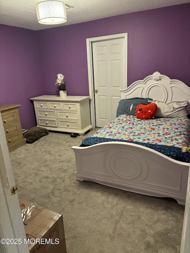 bedroom with a textured ceiling and carpet floors