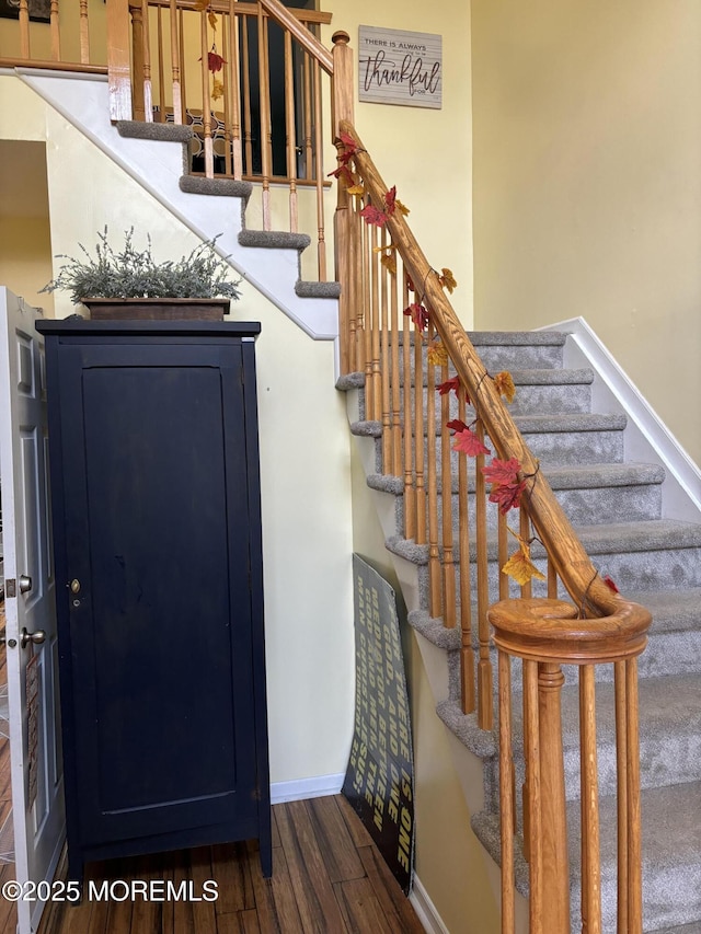 staircase with wood finished floors and baseboards